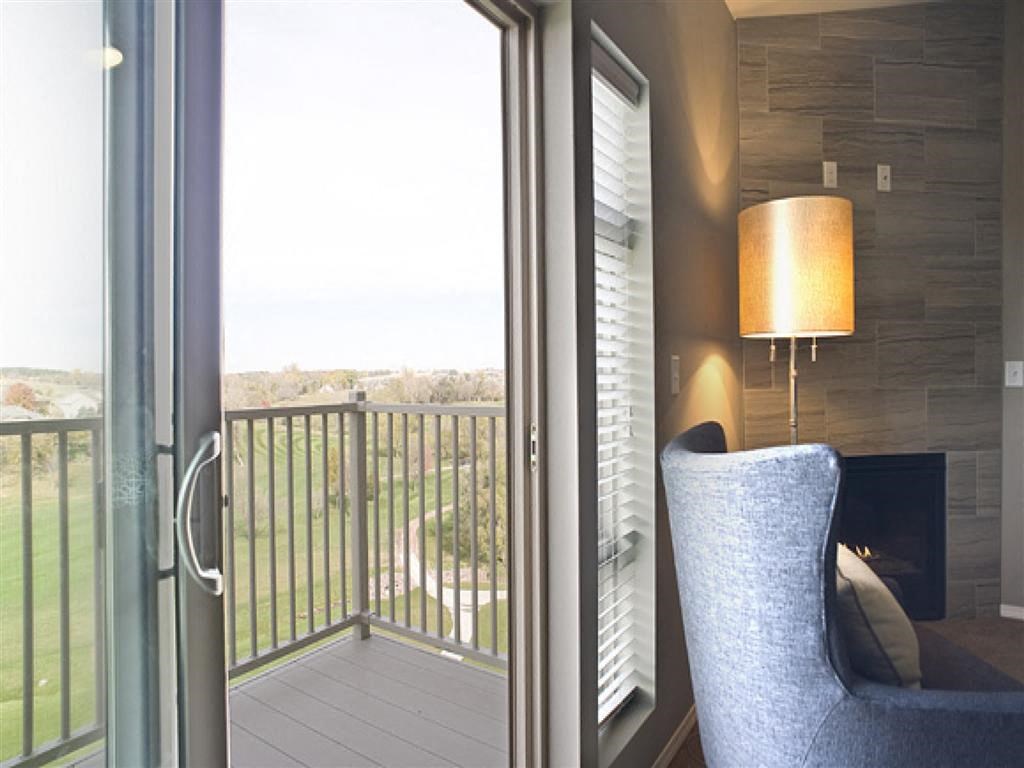 a living room with a chair and a balcony