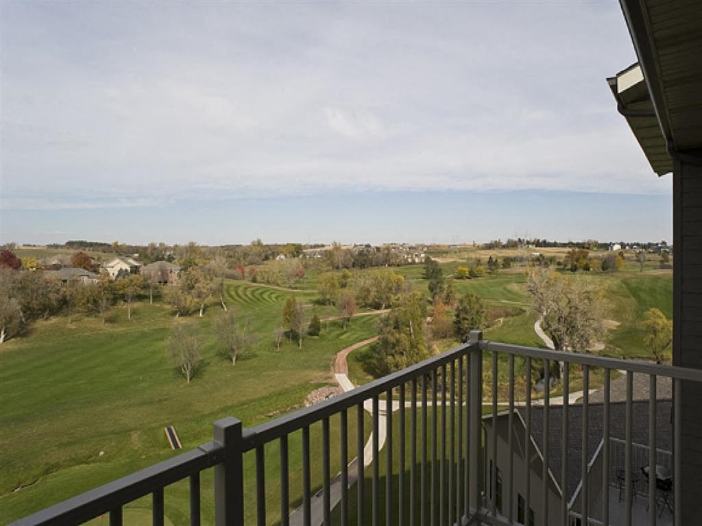 the view from the deck of a house overlooking a golf course