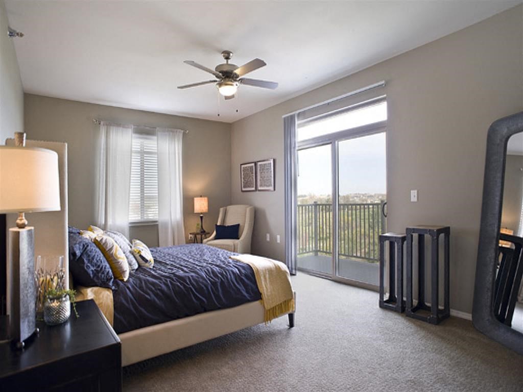 a bedroom with a bed and a ceiling fan and a window