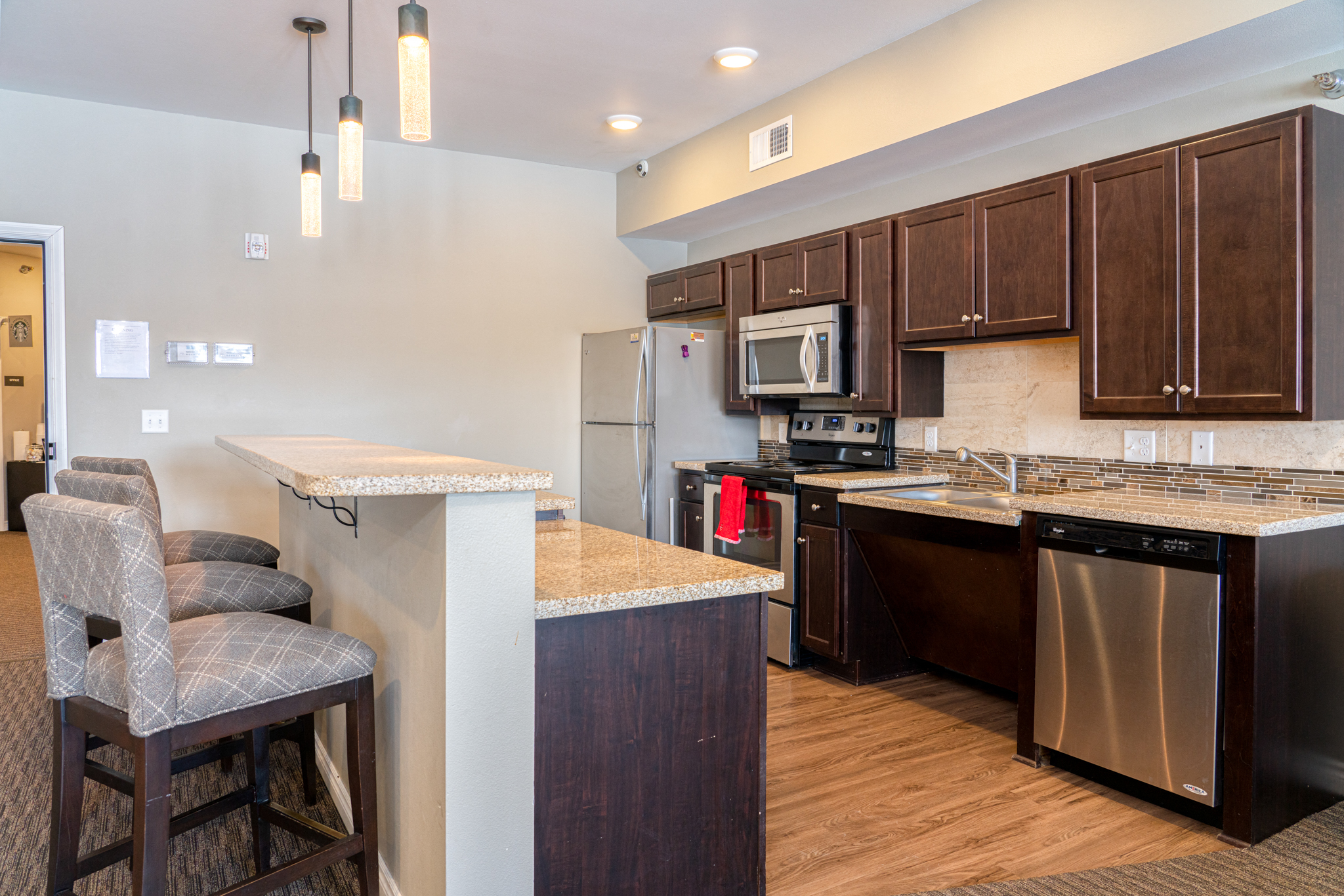 a kitchen with stainless steel appliances and a counter with a bar stool