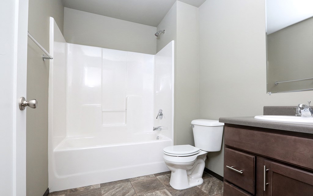 a bathroom with a toilet and a tub and a sink