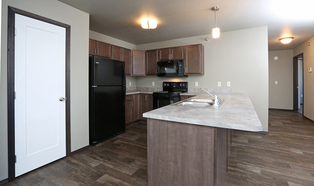 a kitchen with black appliances and a marble counter top