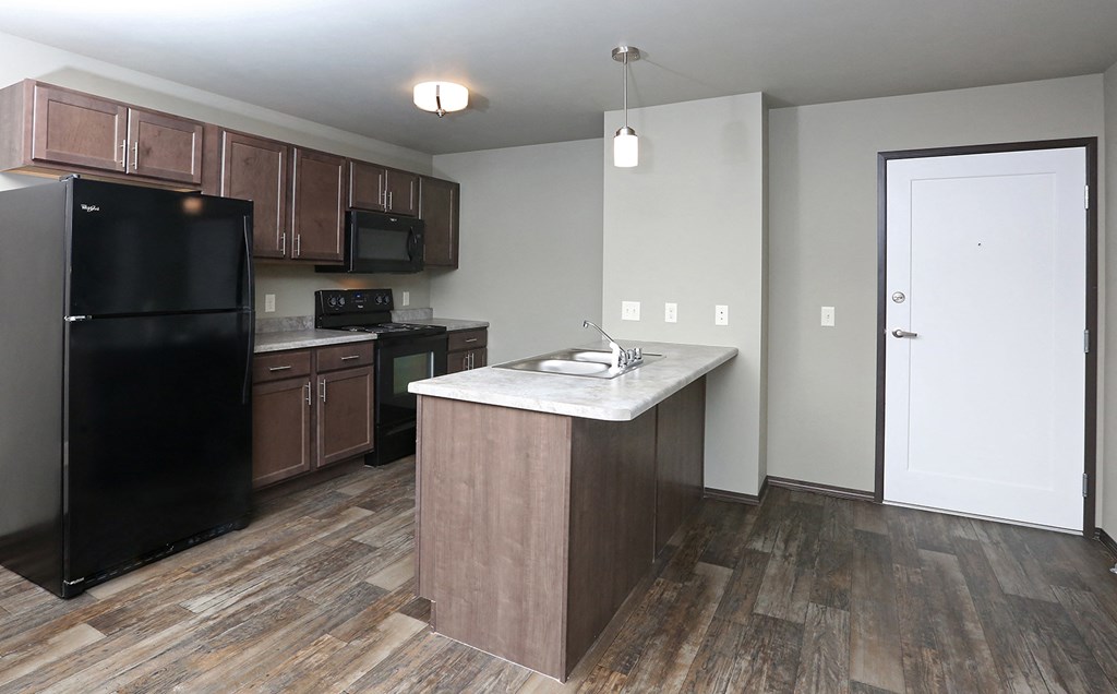 an empty kitchen with a counter top and a refrigerator