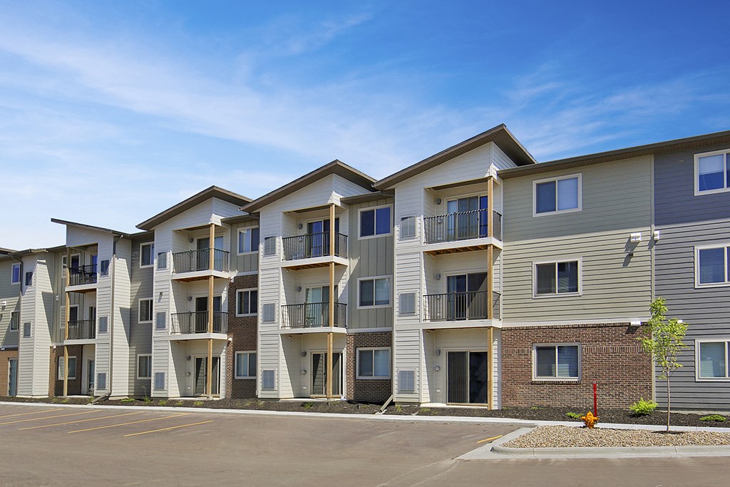 an image of an apartment building with a parking lot