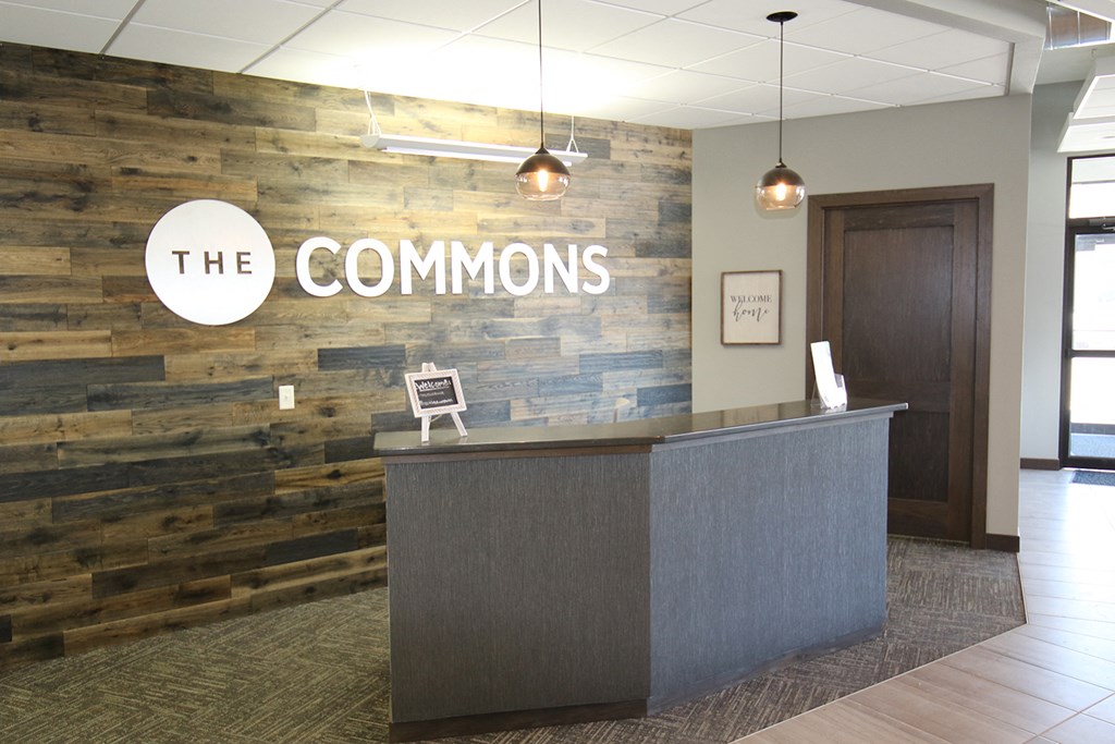 the common lobby with a reception desk and a wood wall