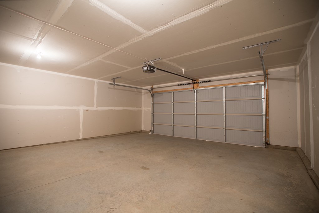 the inside of a garage with a white wall and a garage door