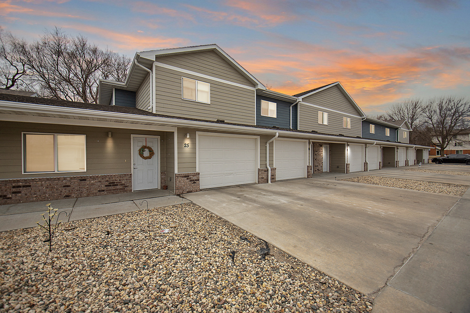 the front of a house at sunset with a paved driveway