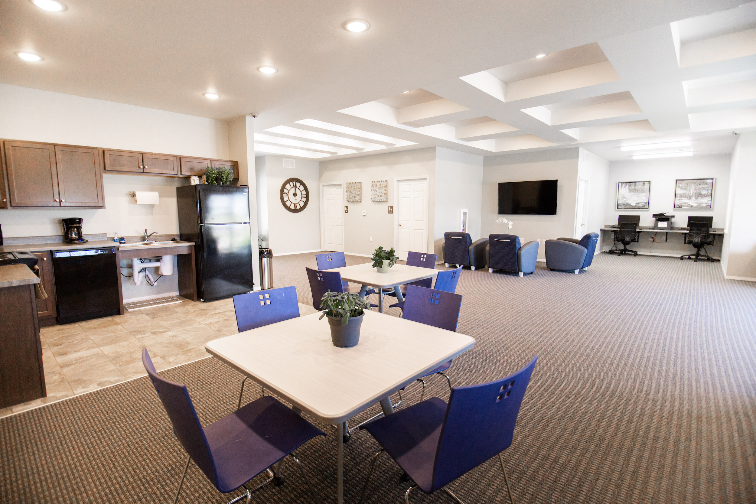 a conference room with a table and chairs and a kitchen