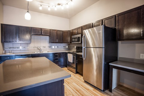 a kitchen with stainless steel appliances and dark wood cabinets