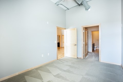 an empty room with a blue wall and a door to a bathroom