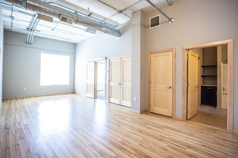 an empty room with wood floors and white walls