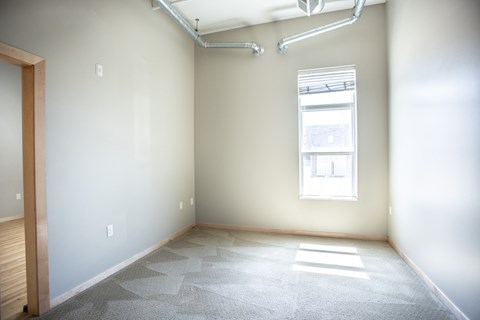 an empty room with white walls and a window