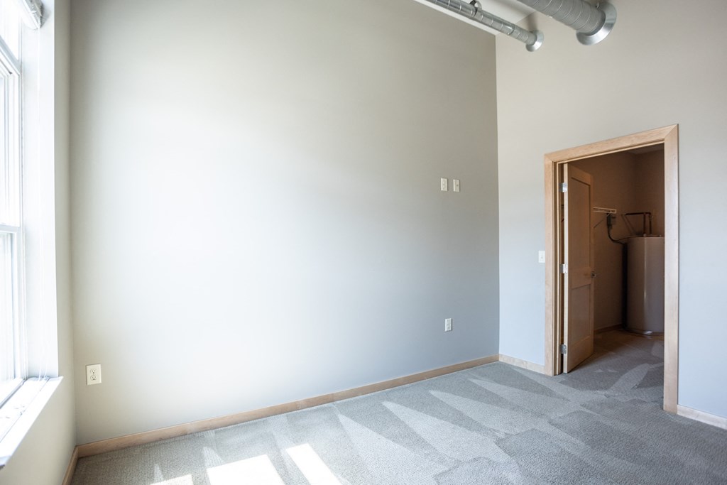 an empty living room with a door to a closet