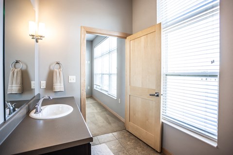 the view of a bathroom with a sink and a door and a window
