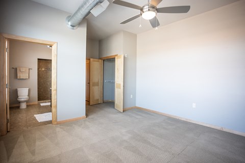 a empty room with a ceiling fan and a bathroom