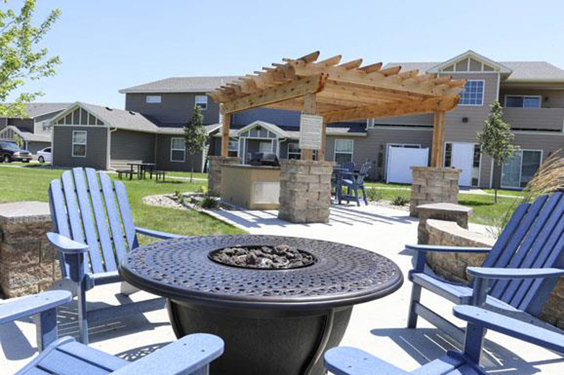 an outdoor patio with chairs and a fire pit
