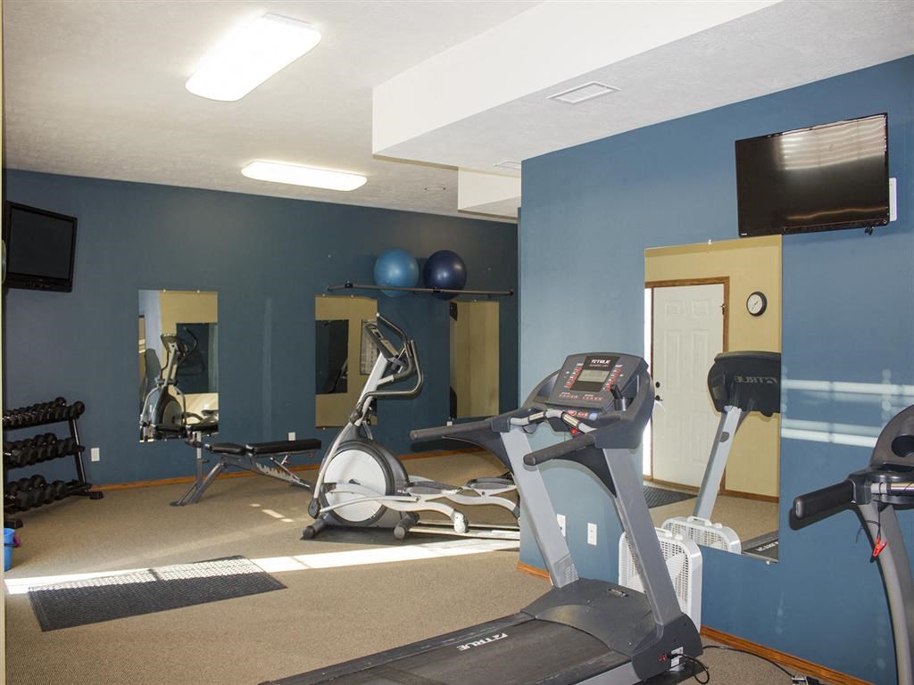 a gym with a treadmill and a tv