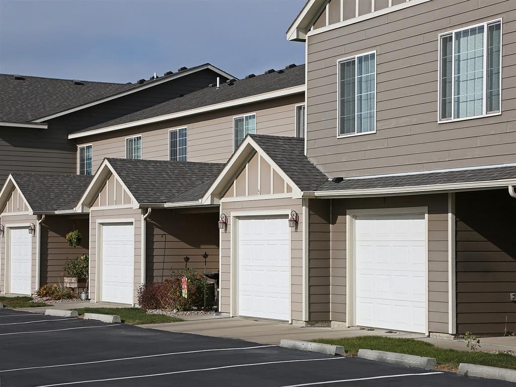 a row of houses with white garage doors