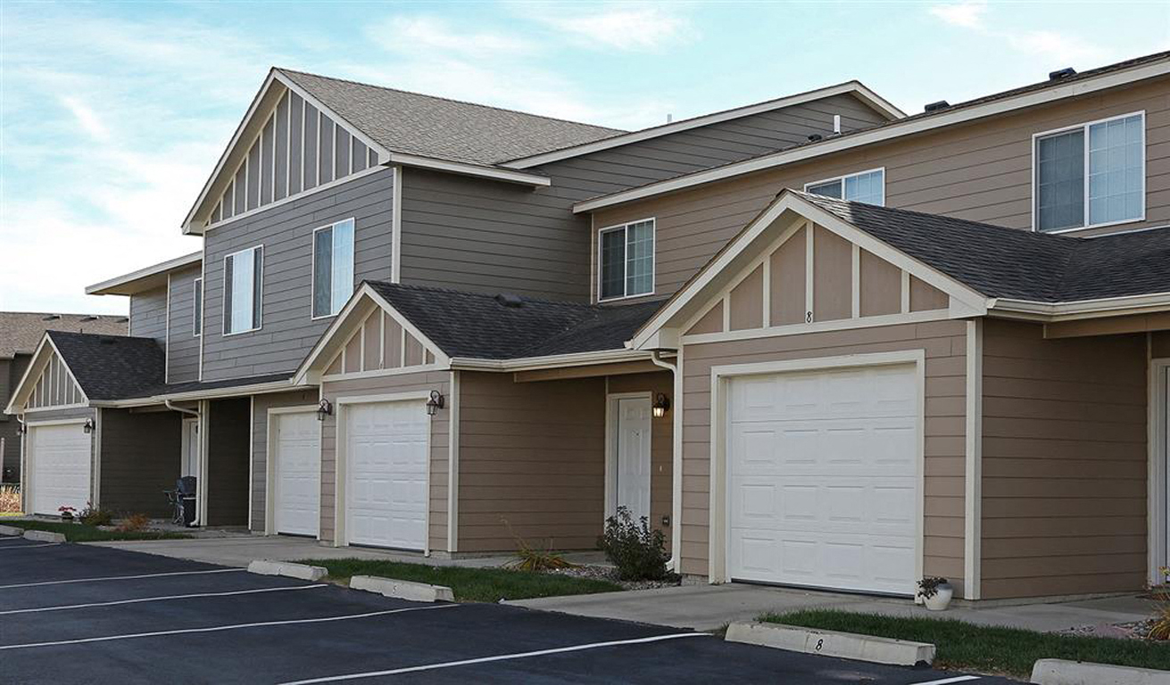 a row of houses with white garage doors