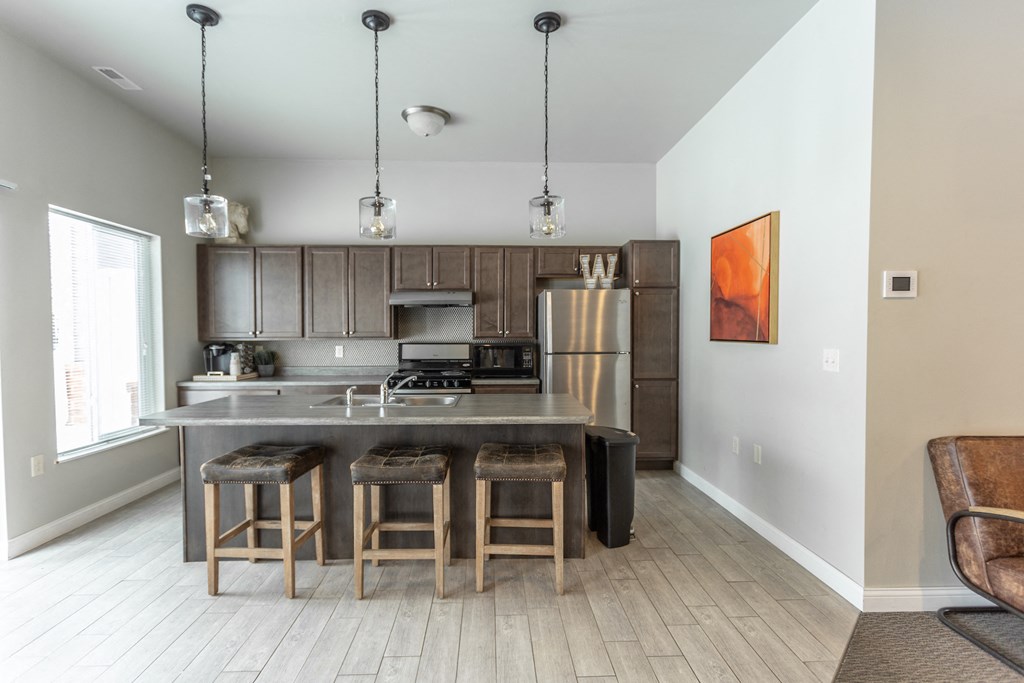 a kitchen with a center island with three stools