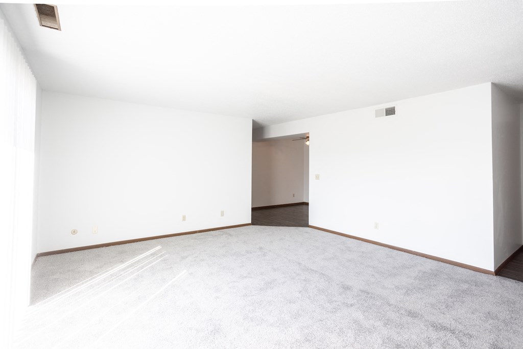 an empty living room with white walls and a concrete floor