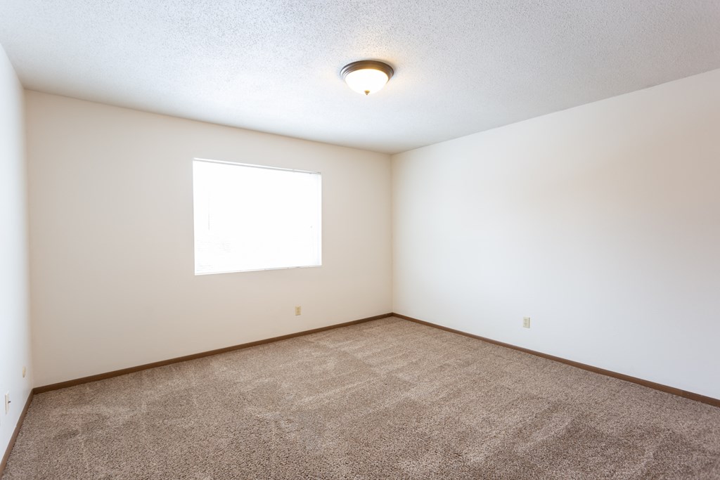 an empty room with carpet and a window