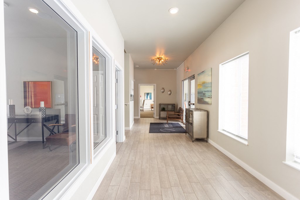 a long hallway with large windows and a sliding glass door