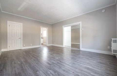 an empty living room with wood floors and a white door