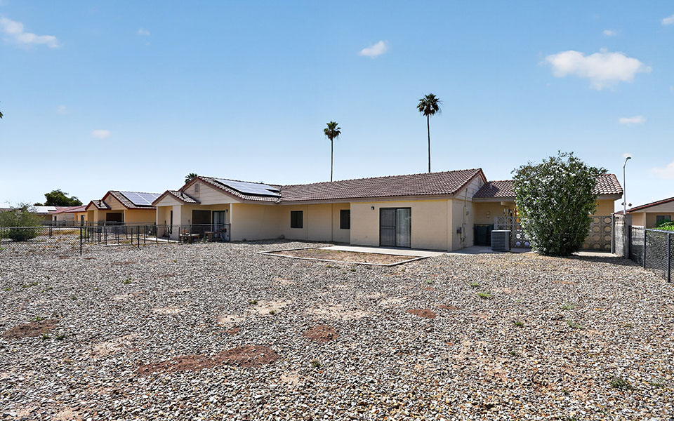 A house with a gravel yard in front.