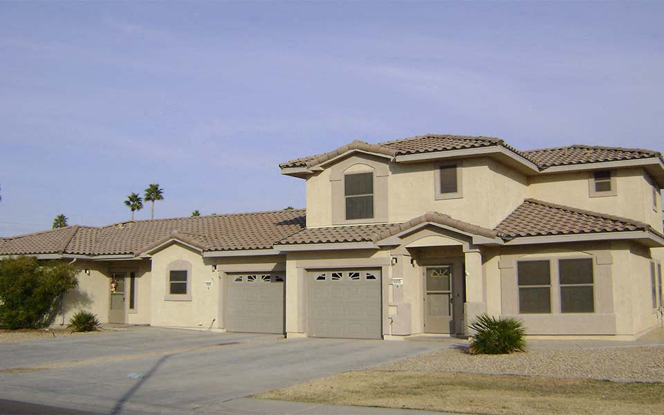 a beige house with two garage doors