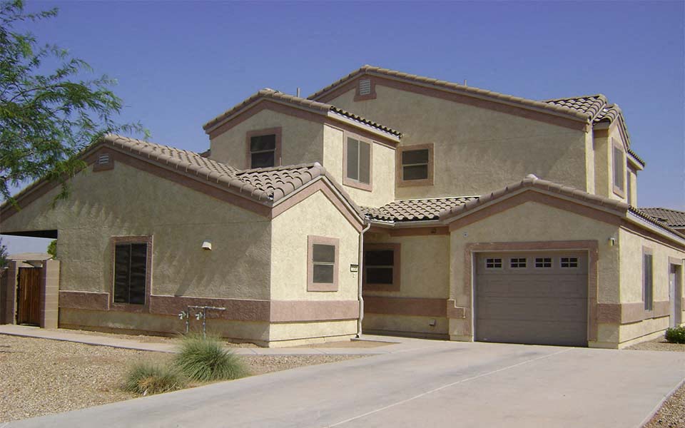 a beige house with a driveway and a garage door