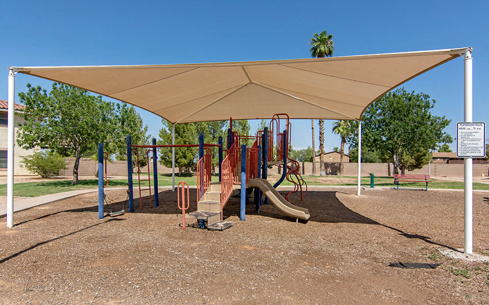 a playground with a shade canopy over it