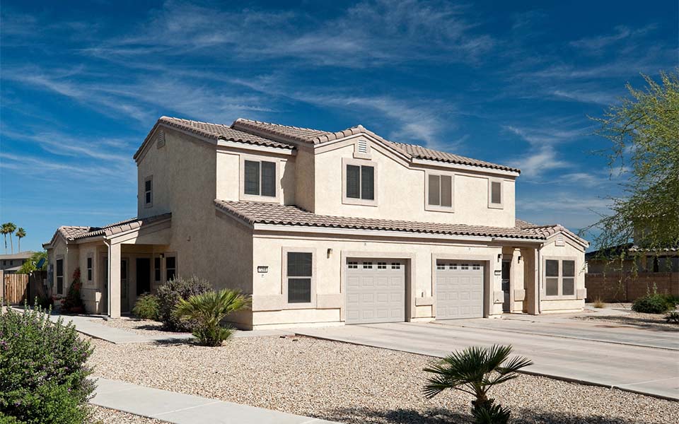 a white house with a garage and a blue sky