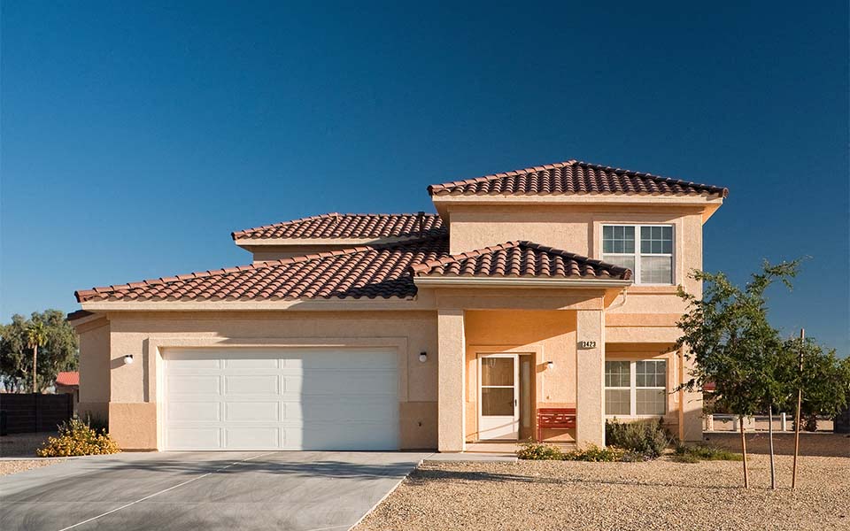 a tan house with a white garage door