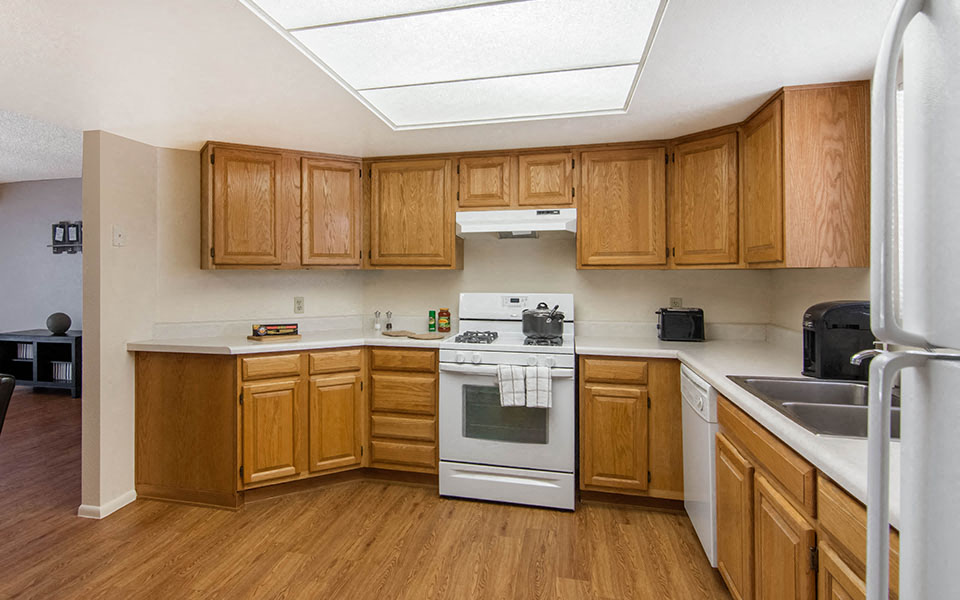 a kitchen with white appliances and wooden cabinets