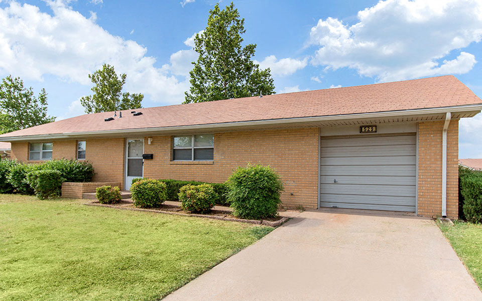 a brick house with a driveway and a garage door
