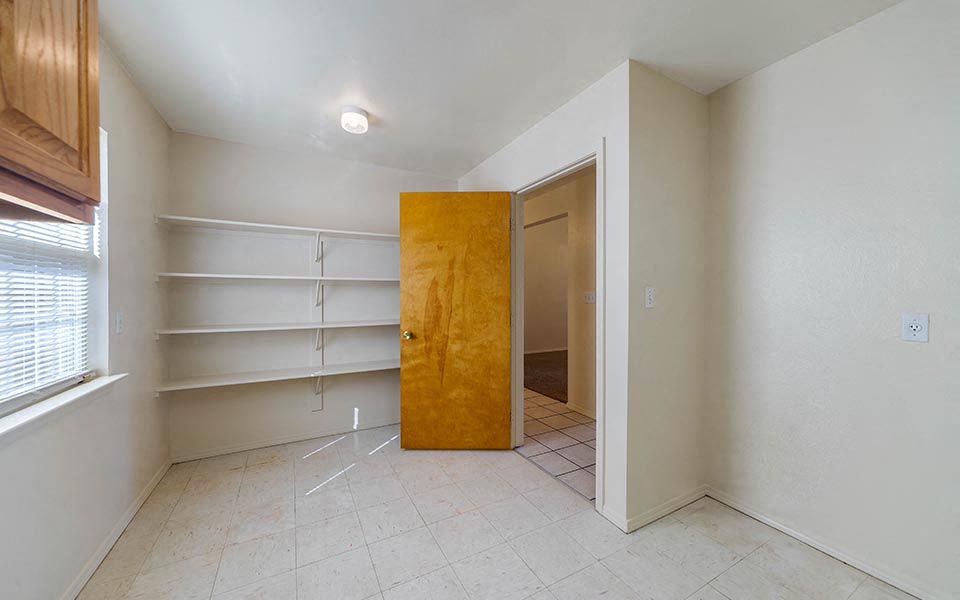 an empty room with an open door to a closet