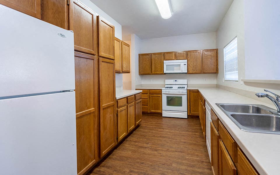 a kitchen with wooden cabinets and white appliances