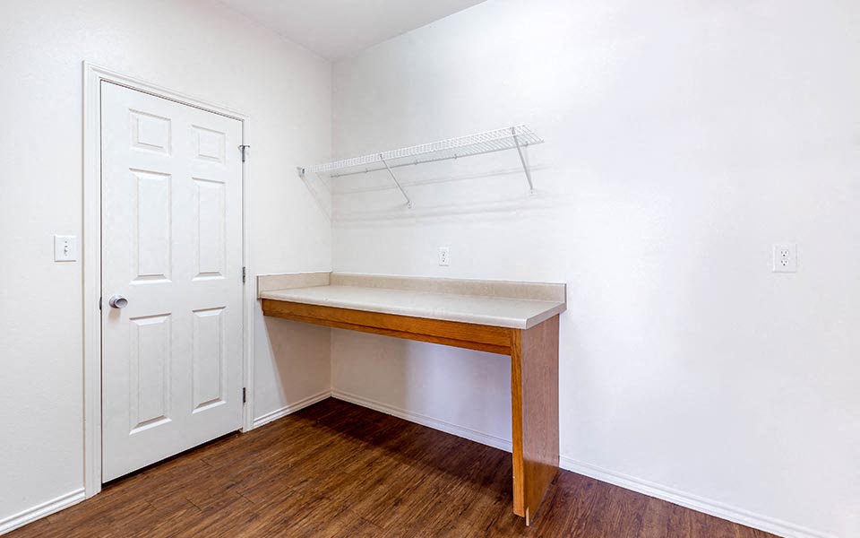an empty room with a desk and a white door