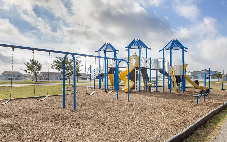 a playground with slides and swings at a park