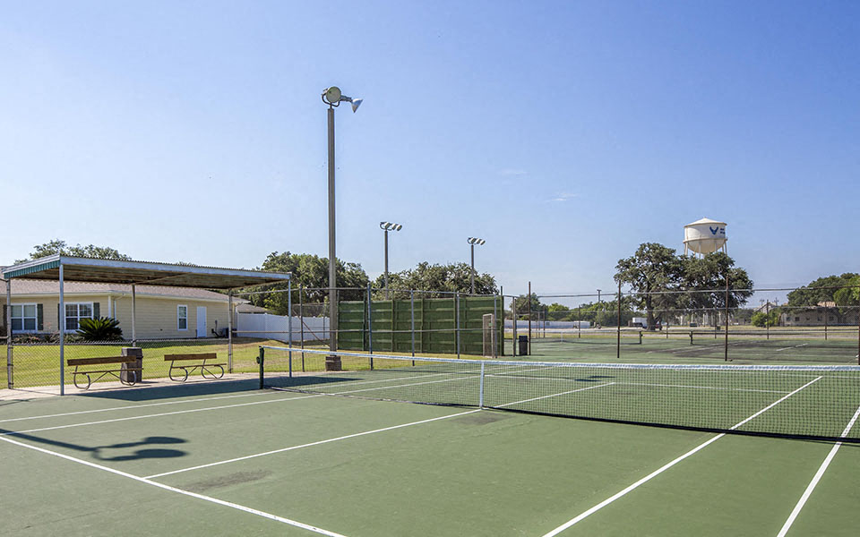 a tennis court with a building in the background