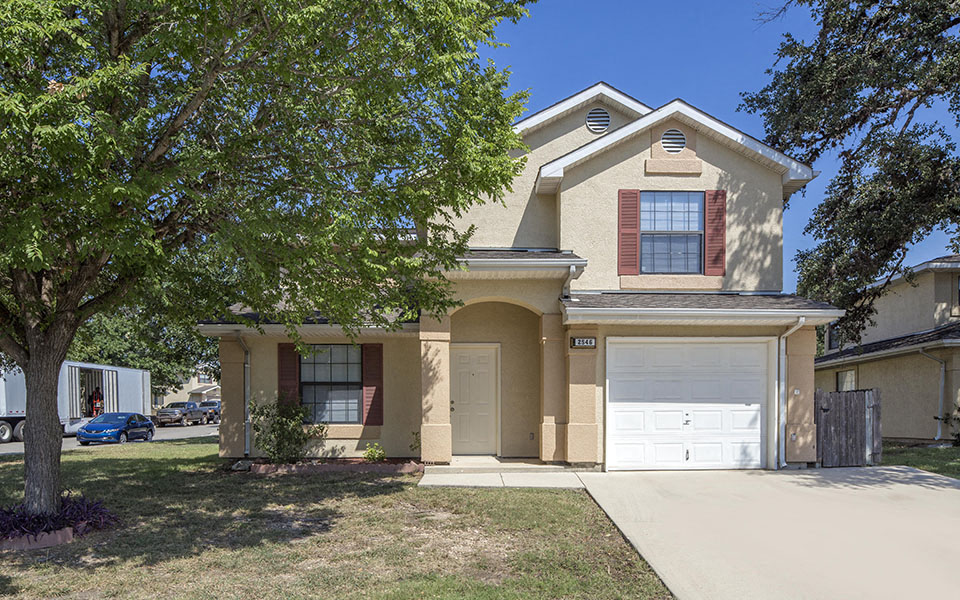 a tan house with a white garage door