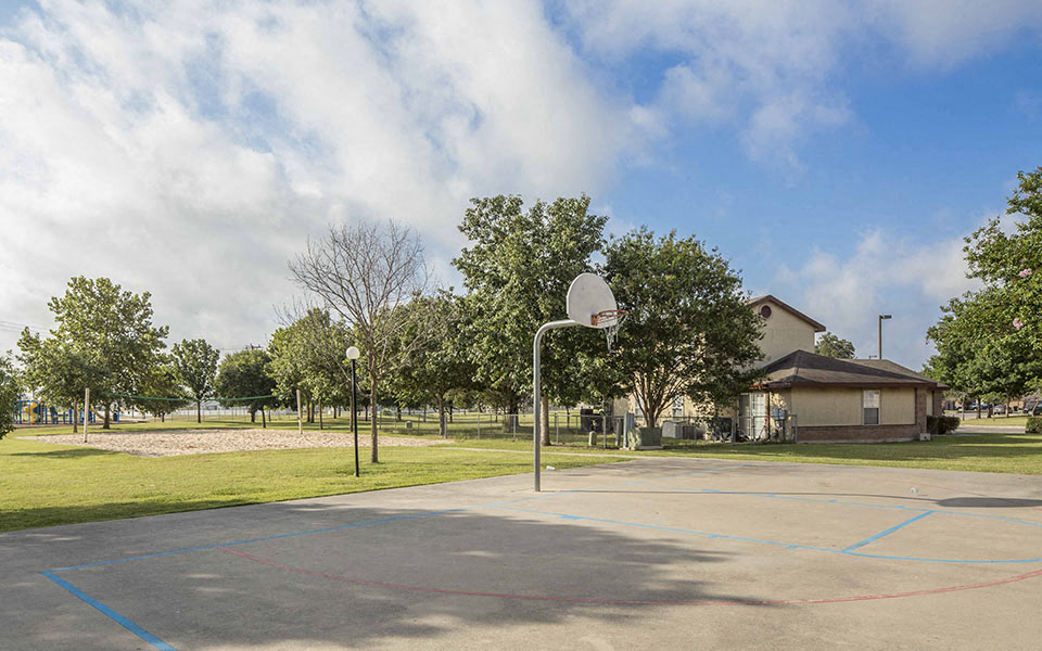 a basketball court in a park next to a building
