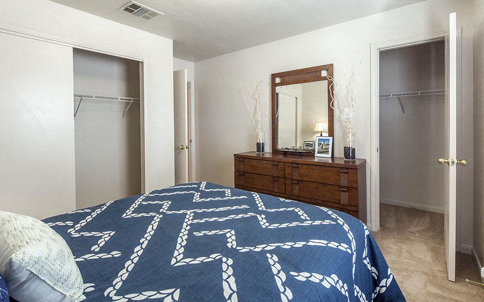 a bedroom with a bed and a dresser with a mirror