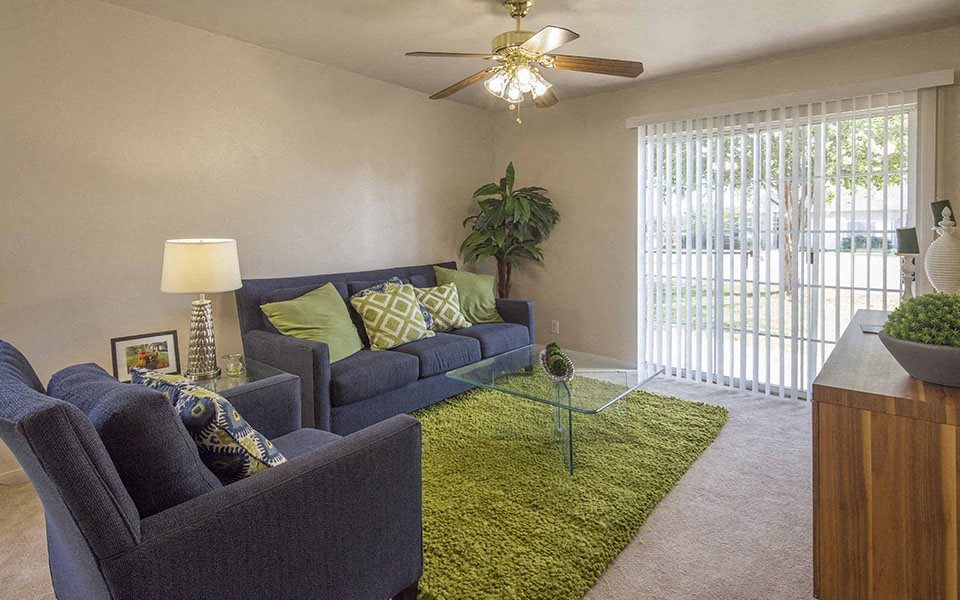 a living room with a couch and a ceiling fan