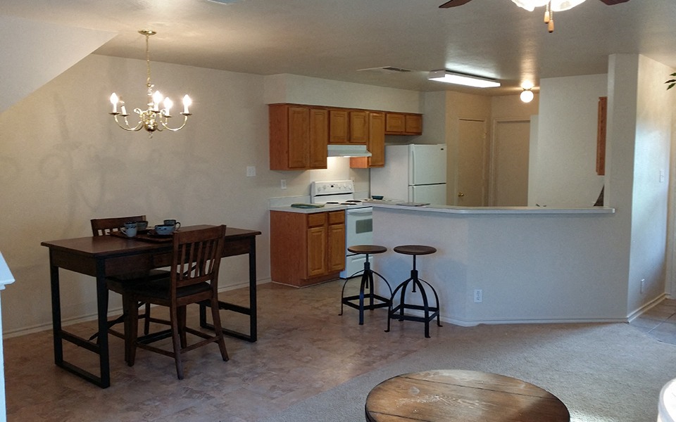 an empty kitchen and dining room with a table and chairs