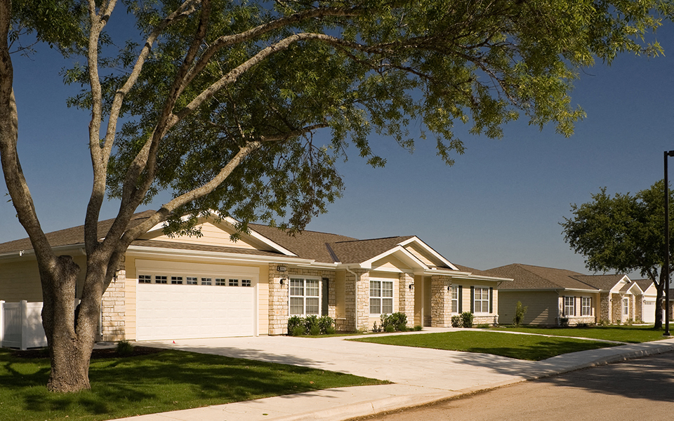 a house with a garage and a tree in front of it