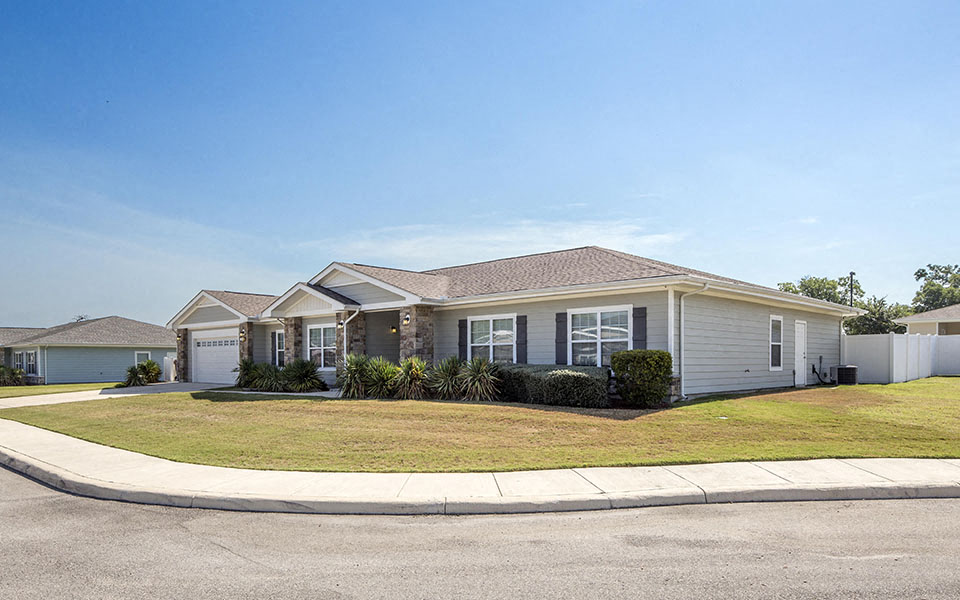 a house with a lawn and a street in front of it