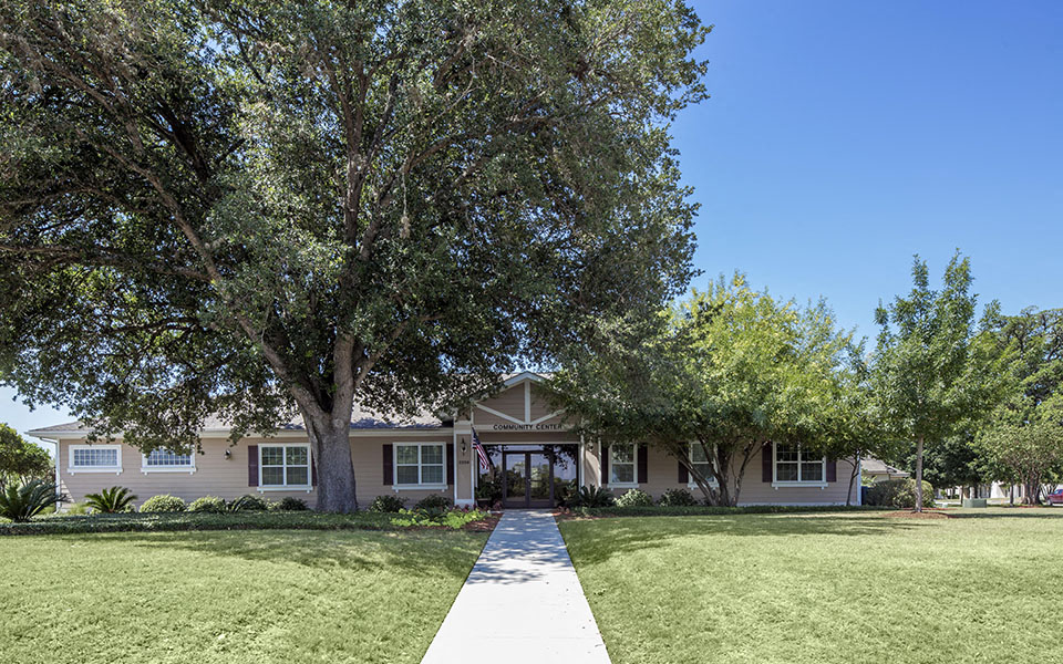 a house with a lawn and trees in front of it