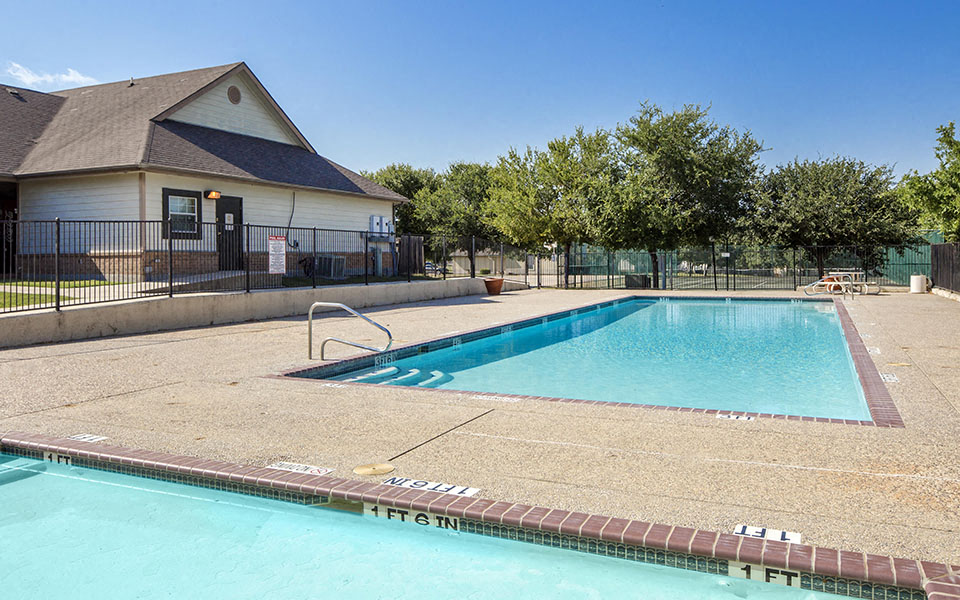 a swimming pool with a house in the background